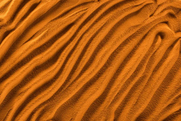 Vista dall'alto di sabbia strutturata con onde e filtro colore arancione — Foto stock