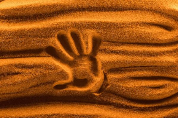 Vista superior da marca de mão na areia com filtro de cor e ondas lisas — Fotografia de Stock