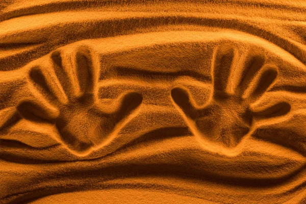 Vista dall'alto dei segni della mano sulla sabbia con filtro colore e onde lisce — Foto stock