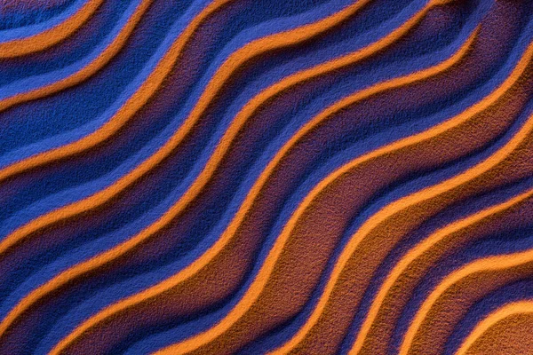 Top view of textured sand with smooth waves and neon color filter — Stock Photo