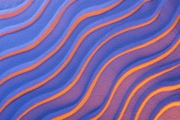Vista superior de arena texturizada con ondas suaves y filtro de color púrpura neón - foto de stock