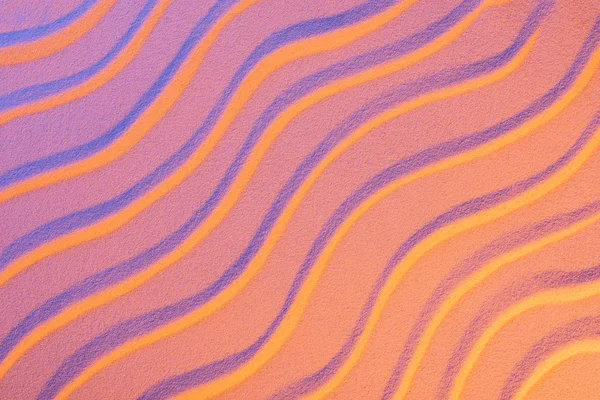 Top view of textured sand with smooth waves and neon pink color filter — Stock Photo