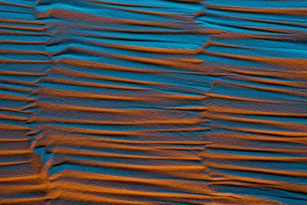 Vue de dessus de fond sablonneux texturé avec filtre de couleur et ondes abstraites — Photo de stock