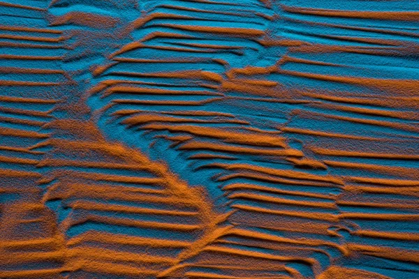 Вид сверху текстурированного песчаного фона с цветным фильтром и абстрактными волнами — стоковое фото