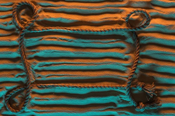 Вид зверху прямих ліній слідів і мотузки на піску з помаранчевим і синім світлом і місцем для тексту — стокове фото