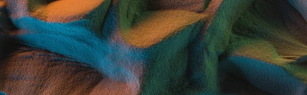 Panoramic shot of textured sand with orange, green and blue lights — Stock Photo