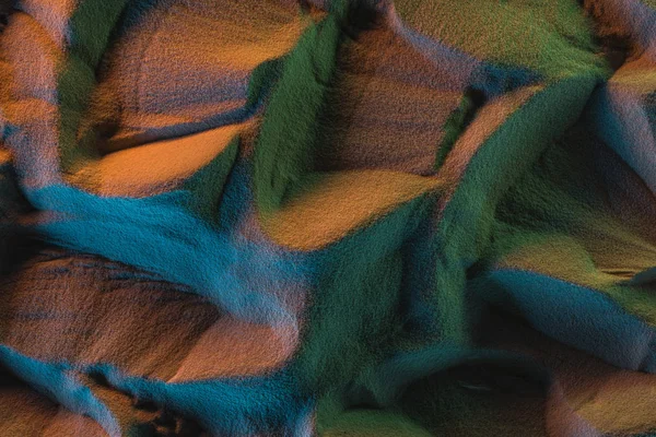 Vue de dessus du sable texturé avec des lumières orange, vertes et bleues — Photo de stock