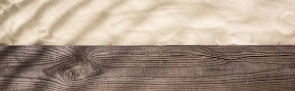 Panoramic shot of wooden brown board and sand with shadow and copy space — Stock Photo