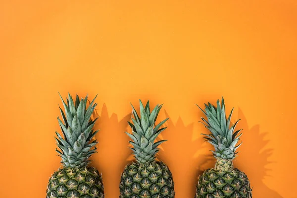 Vista dall'alto degli ananas su sfondo arancione con spazio di copia — Foto stock