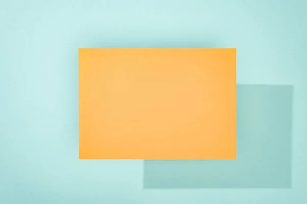 Orange empty card with copy space and shadow on turquoise background — Stock Photo