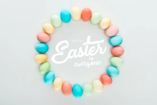 Top view of round frame made of painted multicolored eggs with happy Easter to everyone white lettering — Stock Photo