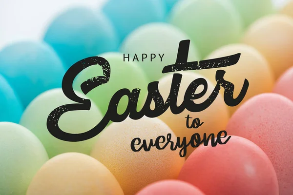 Black happy Easter to everyone lettering on background of multicolored painted eggs — Stock Photo