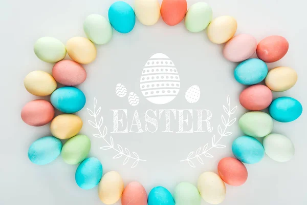 Top view of round frame made of painted multicolored eggs with Easter white lettering — Stock Photo