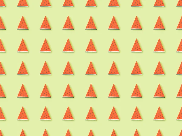 Draufsicht des Musters mit arrangierten handgeschöpften Wassermelonenscheiben auf grünem Papier — Stockfoto