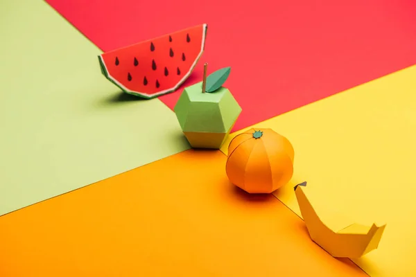 Origami sandía, manzana, mandarina y plátano sobre papel colorido - foto de stock