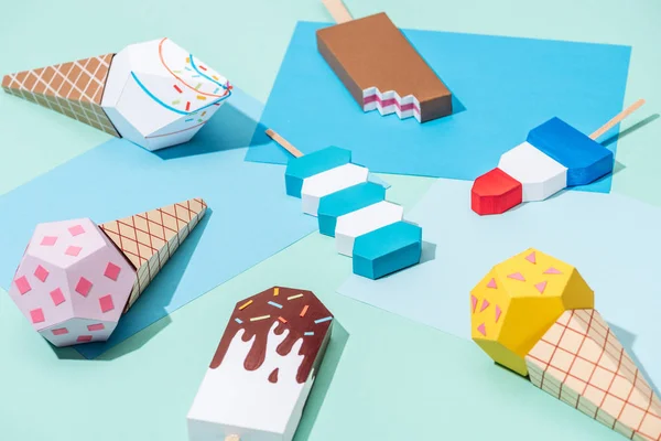 Handmade origami ice cream on blue and turquoise paper — Stock Photo