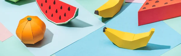 Panoramic shot of handmade cardboard fruits on multicolored paper — Stock Photo