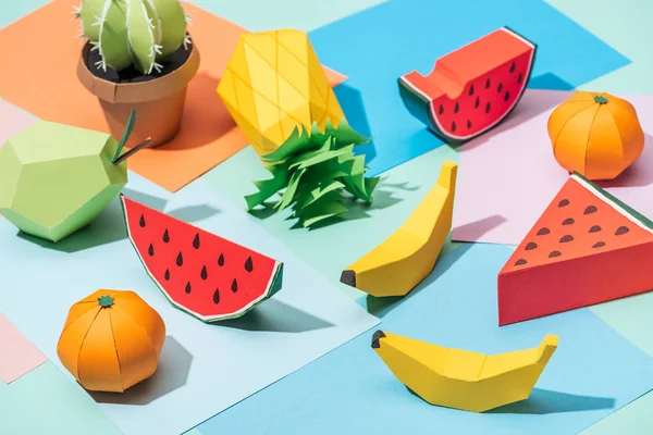 Frutas y cactus de cartón hechos a mano sobre papel multicolor - foto de stock