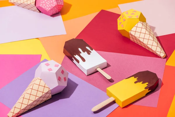 Various handmade origami ice cream on multicolored paper — Stock Photo