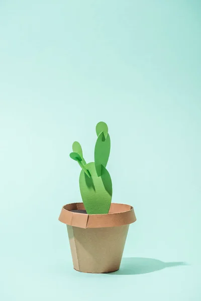 Handmade green paper cactus in flower pot on turquoise with copy space — Stock Photo