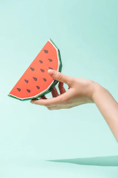 Abgeschnittene Ansicht einer jungen Frau, die Papierwassermelone mit Samen auf Türkis hält — Stockfoto