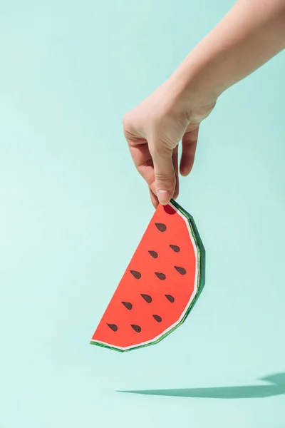 Teilansicht einer jungen Frau, die Papierwassermelone mit Samen auf Türkis hält — Stockfoto