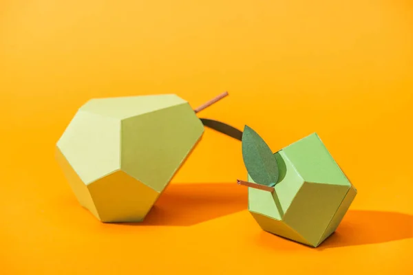 Poire en papier à la main et pomme sur orange avec espace de copie — Photo de stock