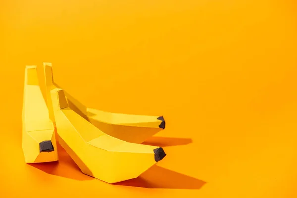 Yellow paper bananas on orange with copy space — Stock Photo