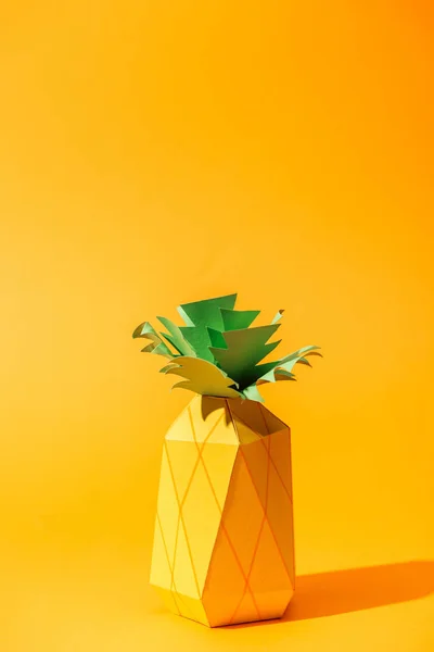 Papier à la main ananas jaune sur orange avec espace de copie — Photo de stock