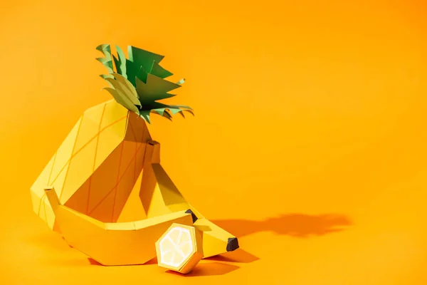 Handmade paper pineapple, bananas and lemon on orange with copy space — Stock Photo