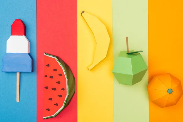 Vista dall'alto di vari frutti di origami e gelato su strisce di carta colorate — Foto stock