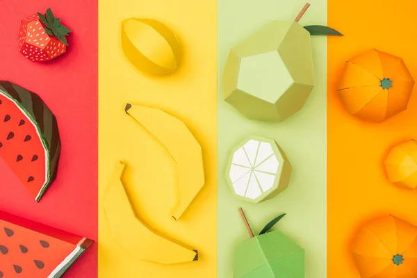 Vista superior de varias frutas de origami en rayas de papel de colores - foto de stock