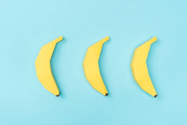 Vista dall'alto di banane di carta gialla disposte isolate su blu — Foto stock