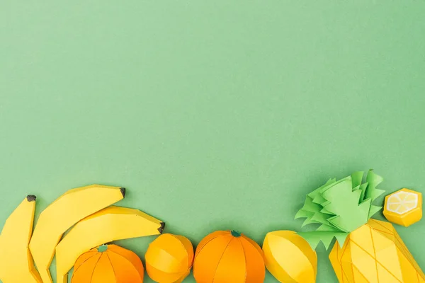 Top view of handmade colorful origami fruits isolated on green with copy space — Stock Photo