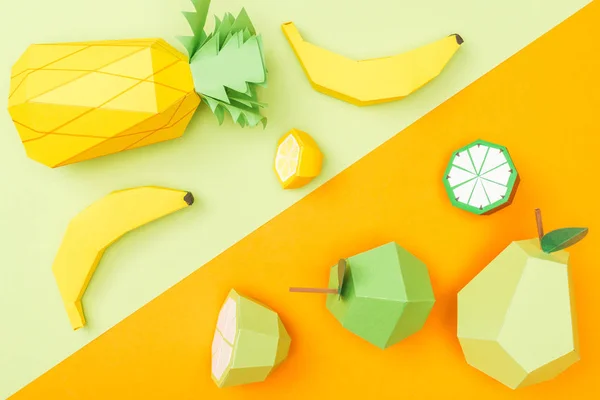 Vista dall'alto di frutta origami colorati fatti a mano su arancione e verde — Foto stock