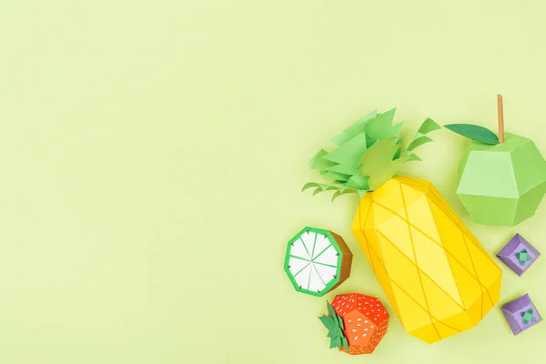 Ansicht von handgeschöpftem Papier Ananas, Erdbeere, Limette und Apfel isoliert auf Grün mit Kopierraum — Stockfoto