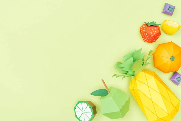 Top view of handmade colorful origami fruits isolated on green with copy space — Stock Photo