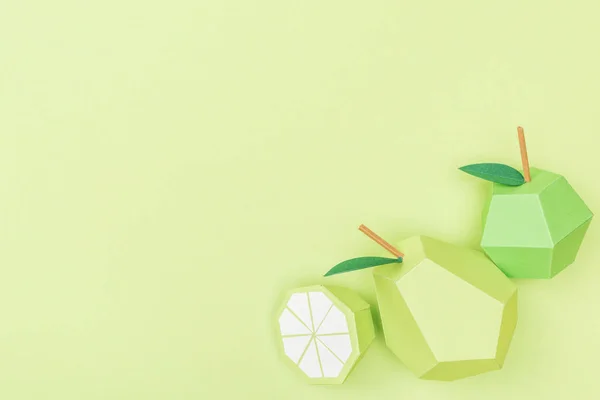 Vue du dessus du papier à la main citron, poire et pomme isolé sur vert avec espace de copie — Photo de stock