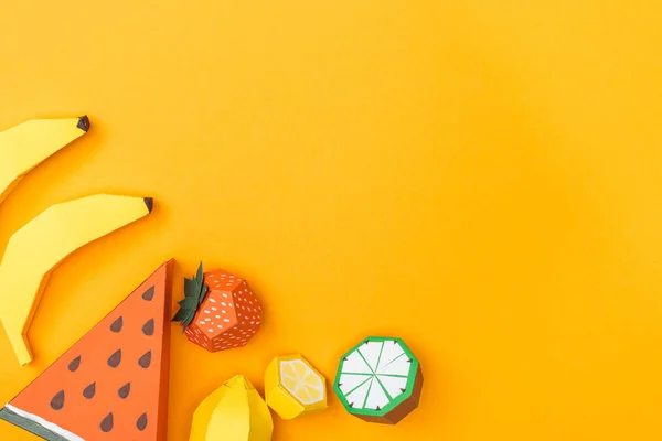 Vista superior de varias frutas de origami coloridas hechas a mano aisladas en naranja con espacio para copiar - foto de stock