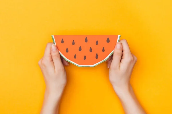 Vista cortada de mulher jovem segurando melancia de papel em laranja — Fotografia de Stock