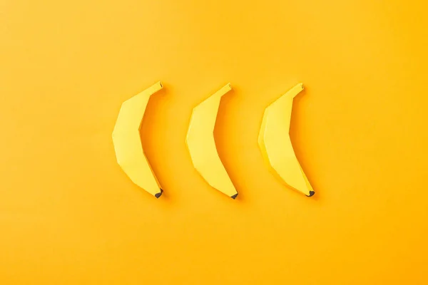 Top view of handmade yellow paper bananas on orange — Stock Photo