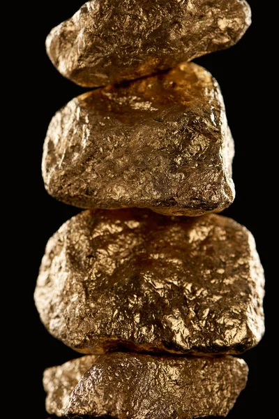 Close up of gold textured shiny stones isolated on black — Stock Photo