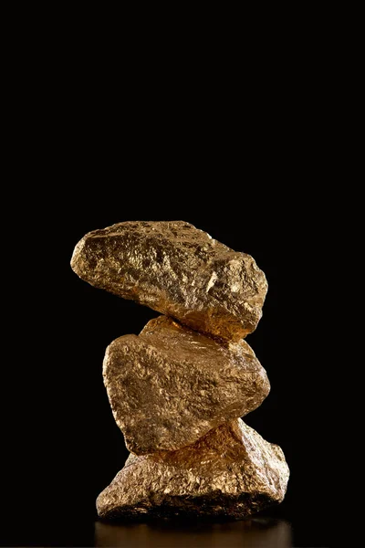 Stack of gold textured stones isolated on black with copy space — Stock Photo