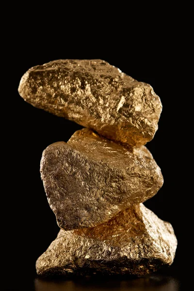 Três pedras brilhantes texturizadas de ouro isoladas em preto — Fotografia de Stock