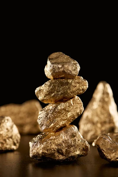 Selective focus of golden shiny stones isolated on black with copy space — Stock Photo