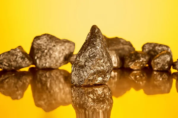 Enfoque selectivo de piedra brillante de oro con reflejo aislado en amarillo - foto de stock