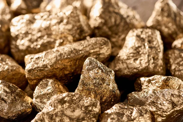 Vista de cerca de oro texturizado piedras brillantes en la luz del día - foto de stock