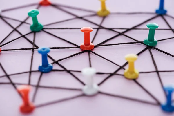 Selective focus of push pins connected with strings Isolated On pink, network concept — Stock Photo