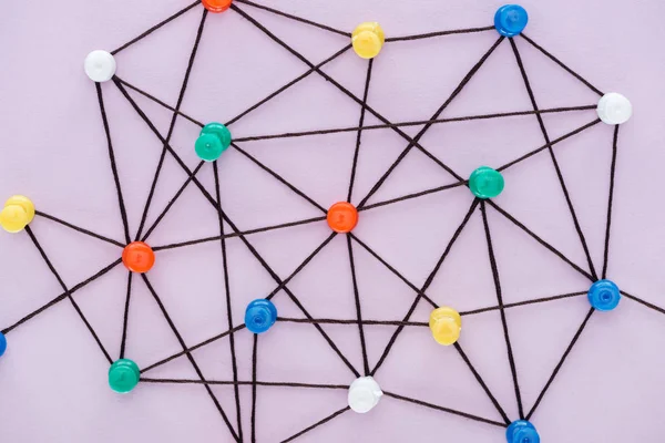 Draufsicht auf Push-Pins, die mit Strings verbunden sind, isoliert auf rosa, Netzwerkkonzept — Stockfoto