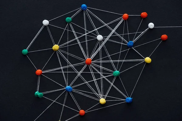 Top view of push pins connected with strings isolated on black, network concept — Stock Photo